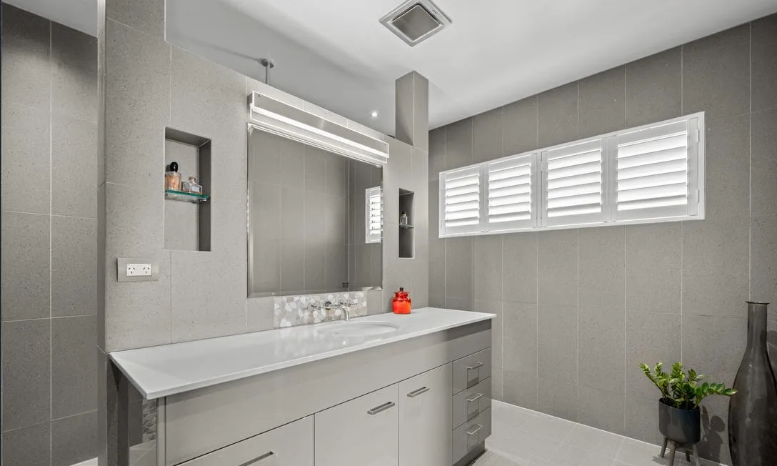 Renovated family bathroom with grey vanity and large mirror