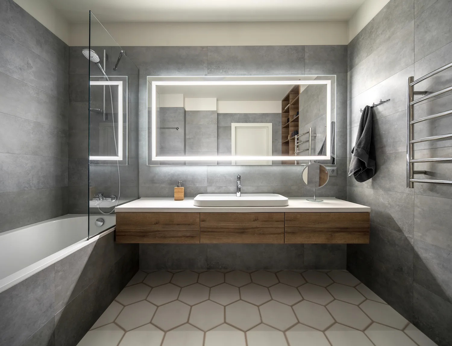 Renovated bathroom with backlit mirror, floating timber vanity and hexagon floor tiles