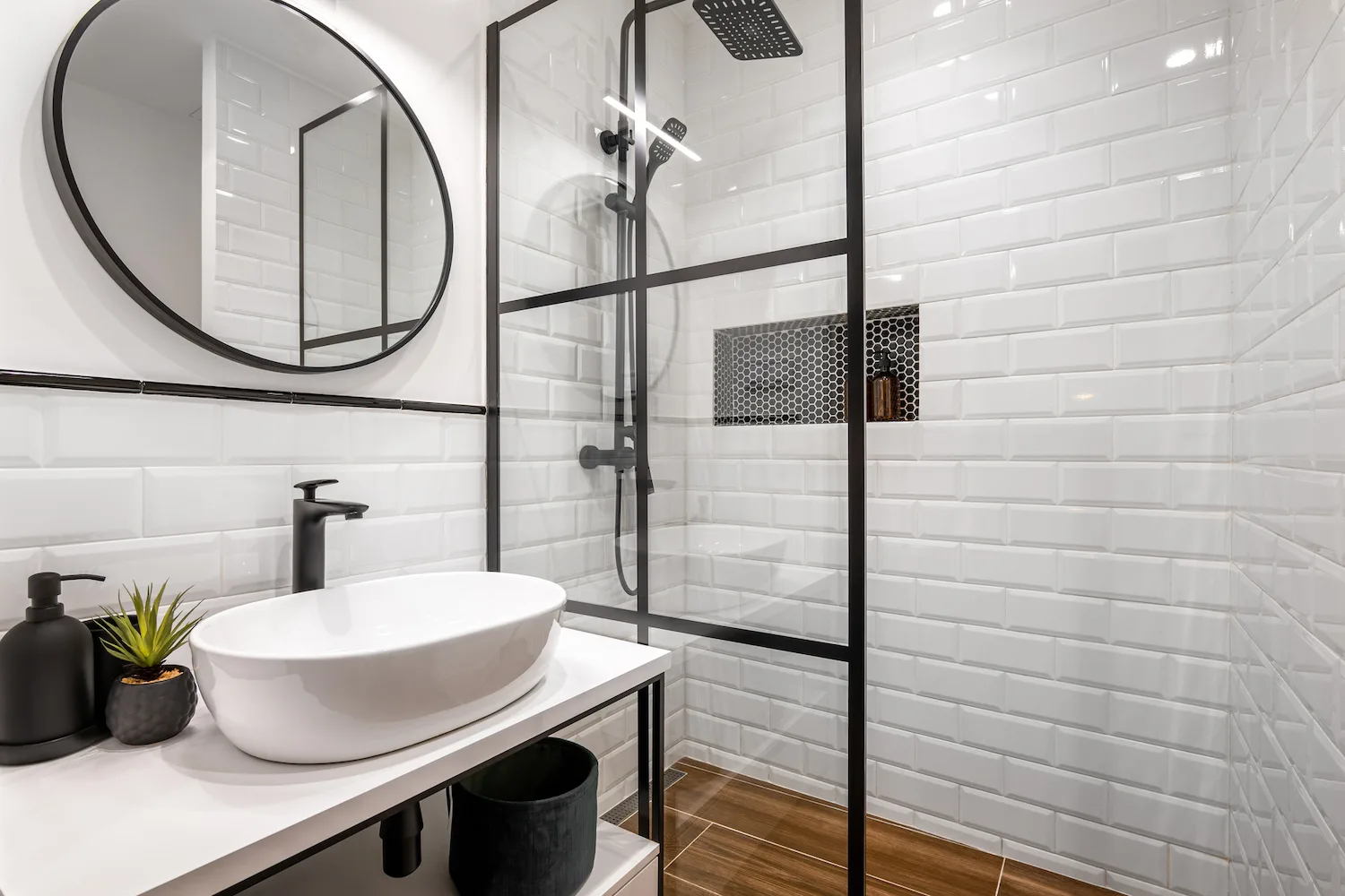 Compact renovated ensuite with black framed shower screen and white subway tiles